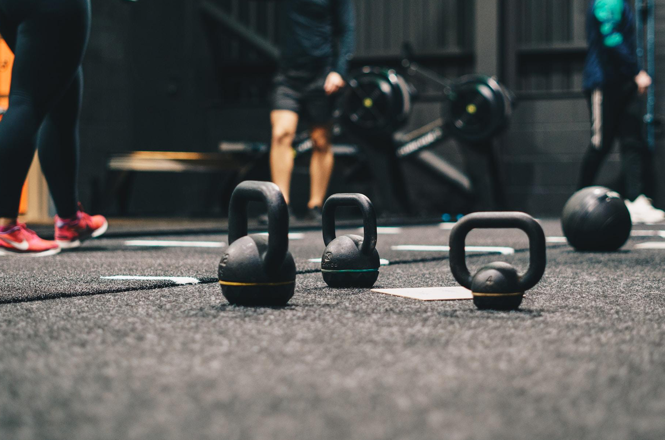 Kettlebells on the gym floor; image by Ambitious Studio* - Rick Barrett, via Unsplash.com.